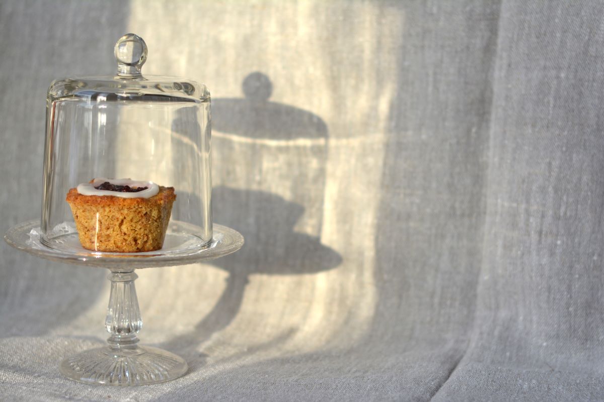 Runebergs tårta på ett glasfat under en glaskupa.